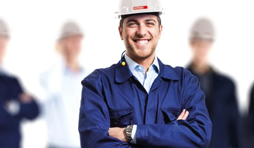 An employee dressed in work clothes smiling at the camera