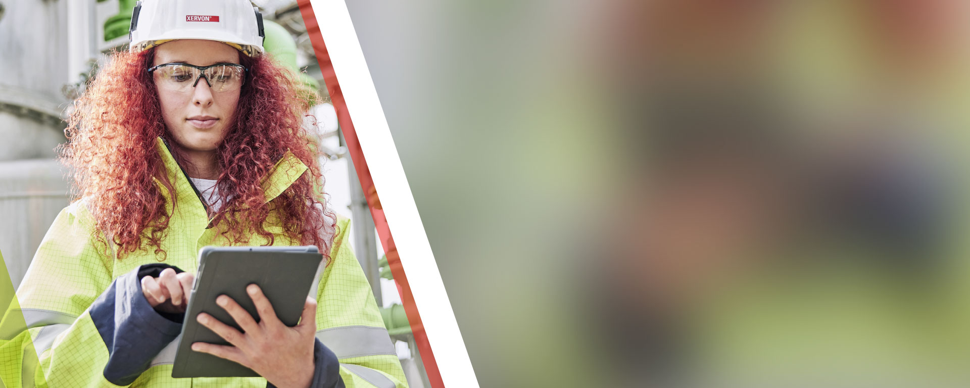 An engineer checking data on her tablet at an industrial estate