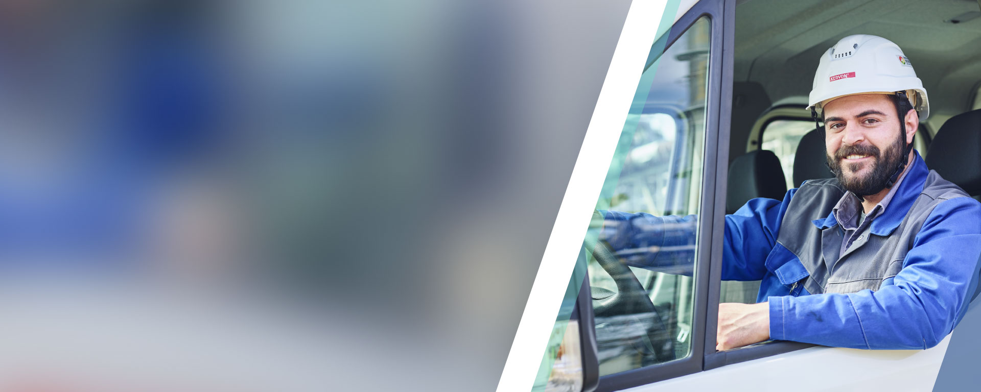 An employee sitting at the wheel of his vehicle and looking out of the window